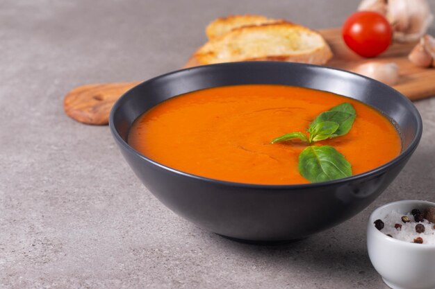 Sopa de tomate fresca y saludable con albahaca, pimienta, ajo, tomates y pan sobre fondo de madera Sopa de gazpacho español Sopa de lentejas y calabaza