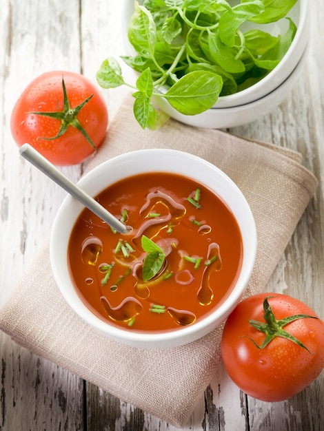 Sopa de tomate con hojas de albahaca en un tazón