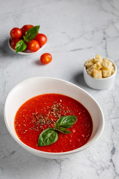 Sopa de tomate en la mesa de la cocina Tomates redondos rojos Solanum y pimentón Fondo de madera