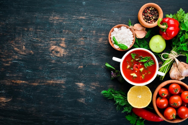 Sopa de tomate con pepino de cebolla y pimentón Vista superior Sobre un fondo negro Espacio libre para texto