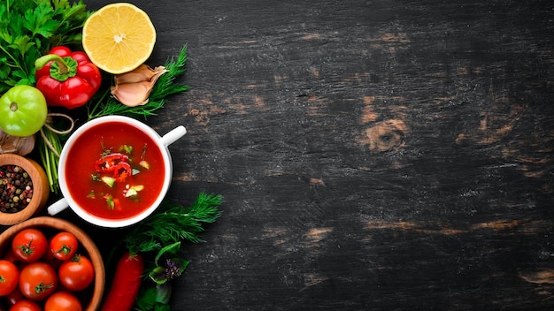 Sopa de tomate con pepino de cebolla y pimentón Vista superior Sobre un fondo negro Espacio libre para texto