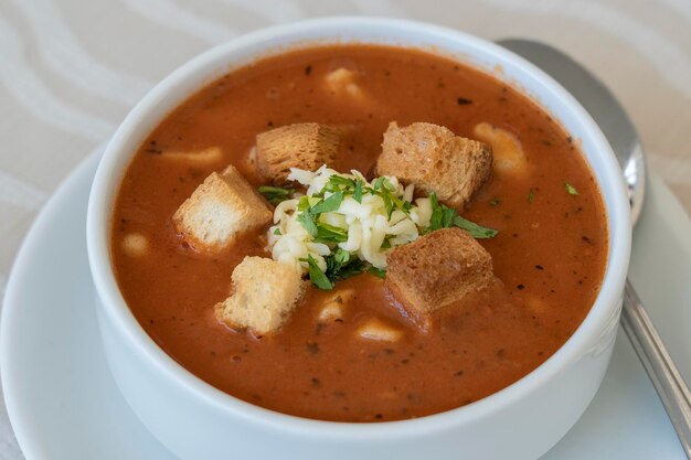 Sopa de tomate con picatostes de queso y primer plano de perejil fresco