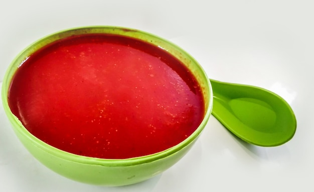 Sopa de tomate en un recipiente aislado sobre fondo blanco.