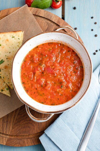 Sopa de tomate sopa de tomate en una vista superior de fondo de madera azul