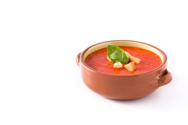 Sopa de tomate en un tazón marrón aislado en blanco