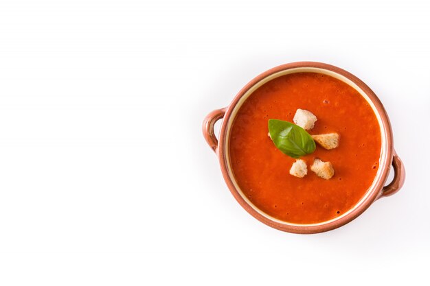 Sopa de tomate en un tazón marrón aislado en blanco