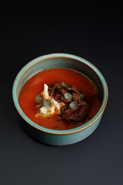 Sopa de tomate con ternera a la parrilla y verduras sobre fondo negro