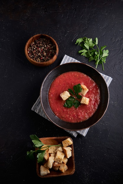 Sopa de tomate tradicional española Gazpacho con especias en un tazón negro