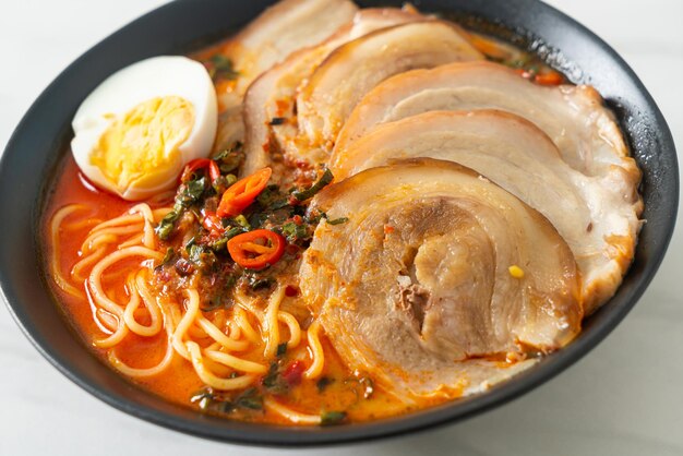 Sopa Tomyum picante de fideos ramen con estilo de comida Fusión de cerdo asado