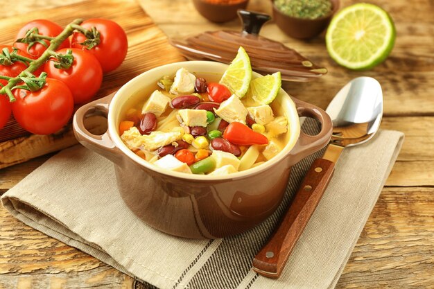 Foto sopa de tortilla de pollo con verduras en la mesa de la cocina