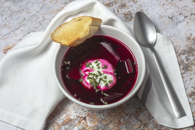 Sopa tradicional de borscht rojo nacional ucraniano y ruso en un tazón con crema agria y hierbas Concepto de comida saludable