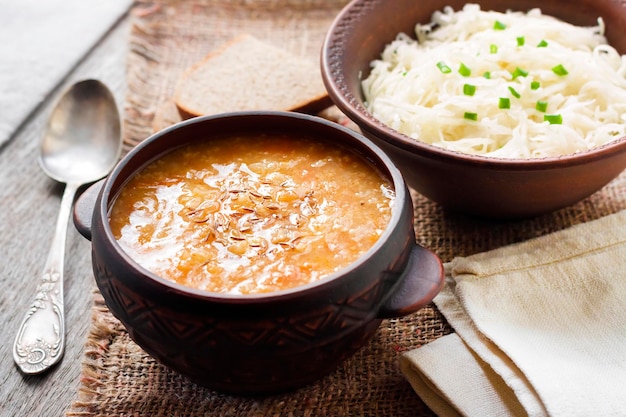 Sopa tradicional ucraniana Kapustnyak con plato de chucrut y mijo en la mesa de Nochebuena