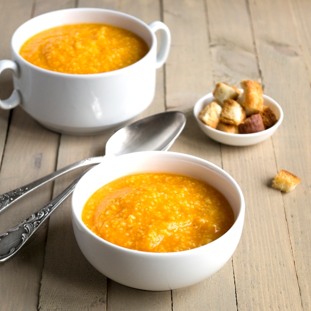 Sopa vegetariana de la calabaza en una tabla de madera.