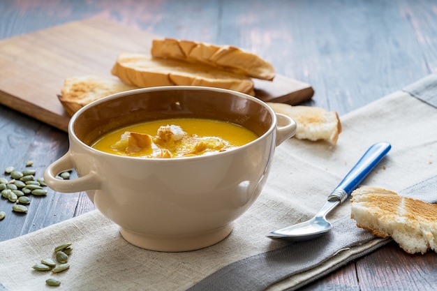 Sopa vegetariana casera de crema de calabaza con semillas y pan