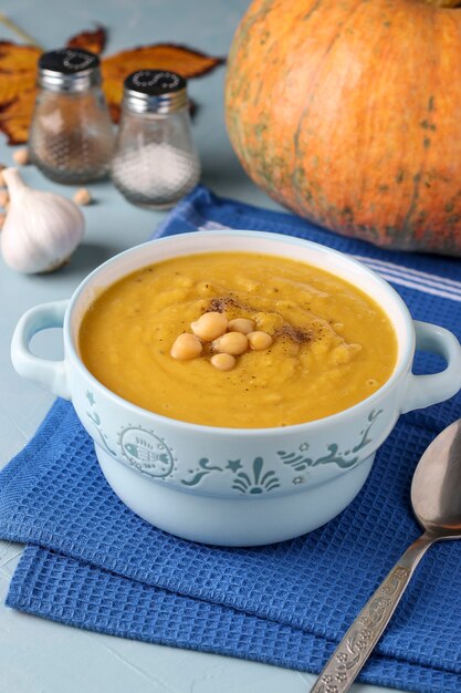 Sopa vegetariana de crema de calabaza de otoño con garbanzos en azul claro