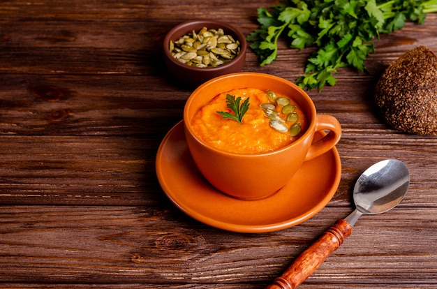 Sopa vegetariana de crema de otoño de calabazas y zanahorias con semillas y perejil