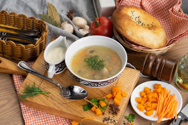 Sopa vegetariana de vegetais com cogumelos, cenoura e endro em prato com tradicional uzbeque