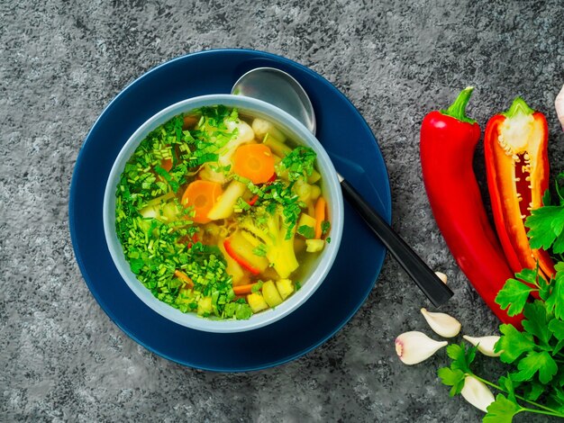 Sopa vegetariana dietética vegetal sana de la primavera, fondo concreto oscuro gris