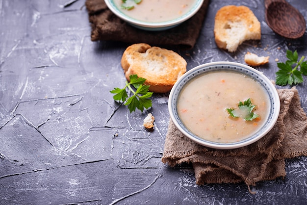 Sopa vegetariana sana de los guisantes en fondo concreto