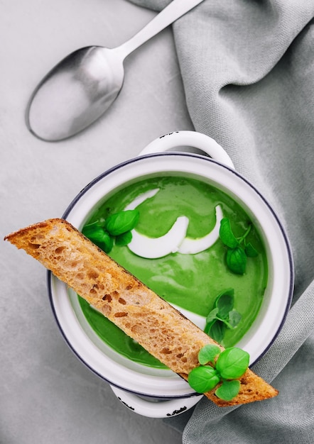 Sopa verde fresca sobre fondo gris