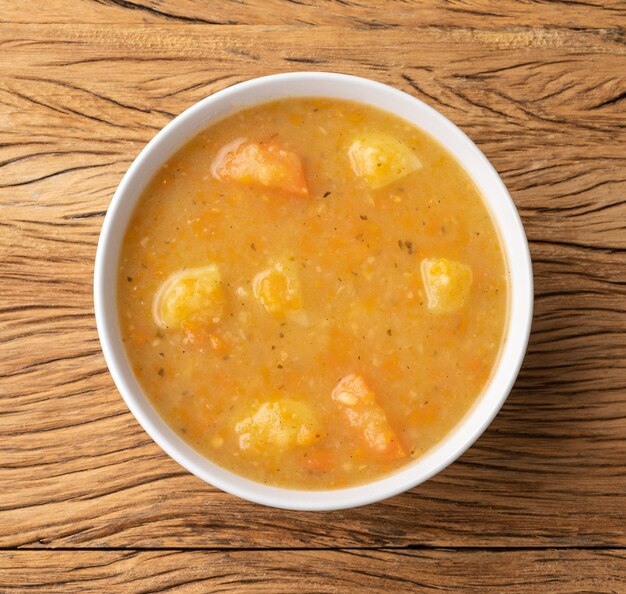 Sopa de verduras en un bol sobre mesa de madera