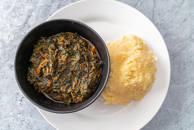 Sopa de verduras caliente picante nigeriana servida con Eba o Garri