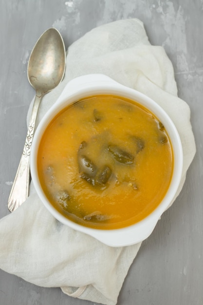 Foto sopa de verduras con galletas en un tazón blanco sobre cerámica