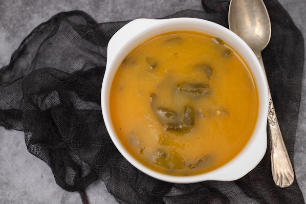 Sopa de verduras con galletas en un tazón blanco sobre cerámica