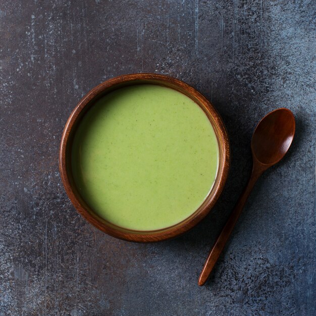 Sopa de verduras verde sobre minimalismo gris negro, vista superior