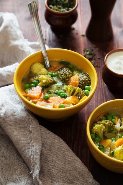 Foto sopa de verduras con zanahorias, guisantes y brócoli