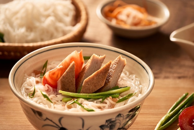 Sopa vietnamita com aletria de arroz e peixe grelhado picado