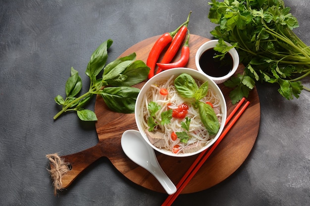 Sopa vietnamita pho bo com ervas, carne, macarrão de arroz, pimenta e broto de feijão.