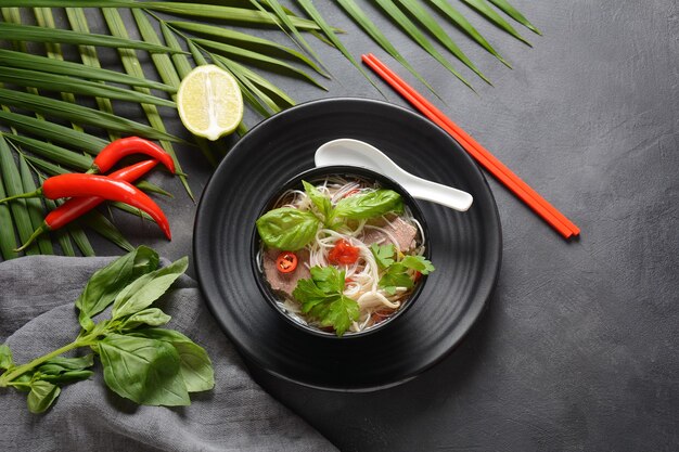 Foto sopa vietnamita pho bo con hierbas, carne de res, fideos de arroz, chile y brotes de soja