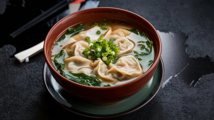 Foto sopa wonton saborosa sopa de bolinhos ou pangsit kuah servida em uma tigela em fundo escuro