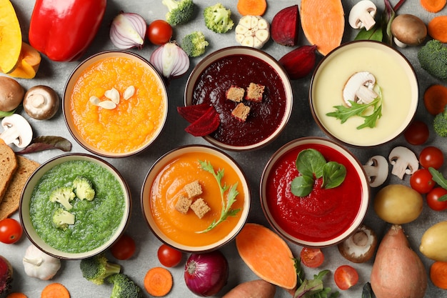 Sopas de verduras e ingredientes en gris, vista superior