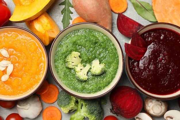 Sopas de verduras e ingredientes en gris, vista superior