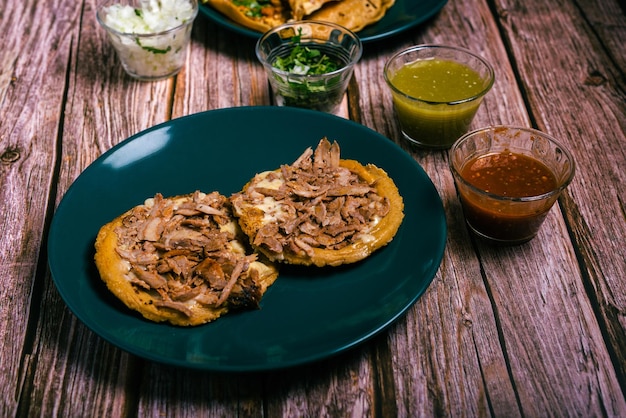 Sope pocho comida típica mexicana servida com condimentos em uma mesa de madeira