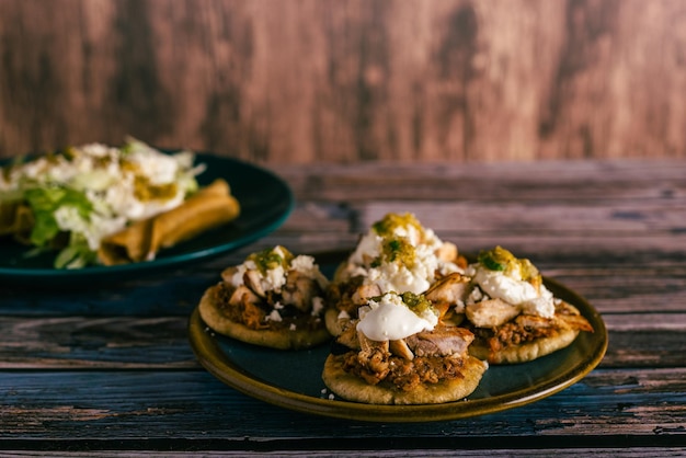 Sopitos typisch mexikanisches Gericht auf Holztisch Sopes mexikanischer Snack