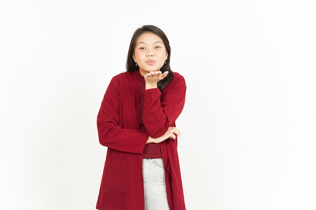 Soplando beso de hermosa mujer asiática vistiendo camiseta roja aislado sobre fondo blanco.