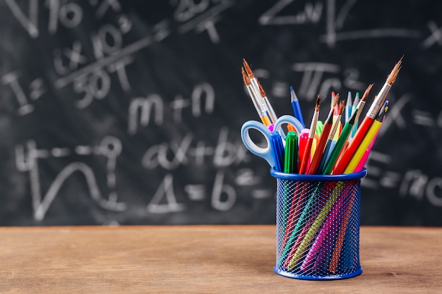 Soporte para lápiz azul con herramientas de dibujo colocadas en el escritorio