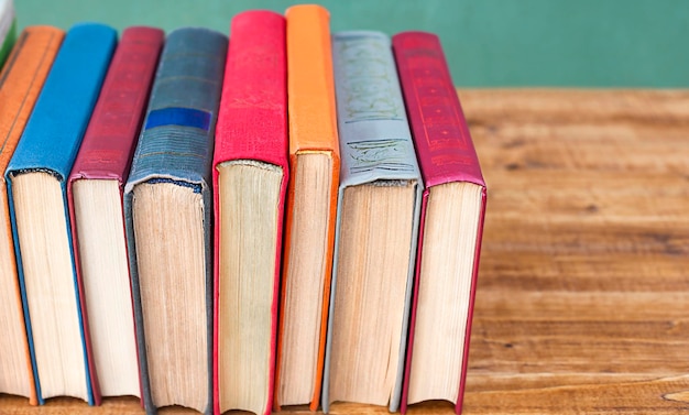 Foto soporte de libros multicolores en un primer plano de la mesa de madera