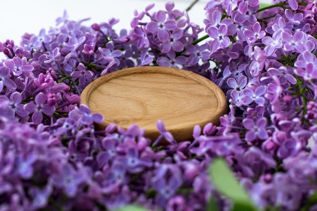 Soporte de madera rodeado de lilas Fondo redondo de madera