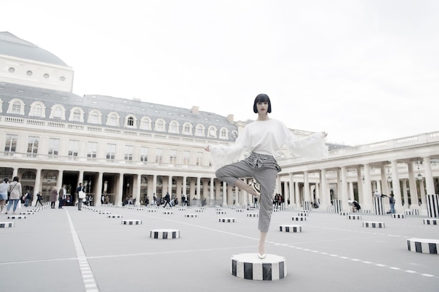 Soporte de la muchacha de belleza en pose de yoga en parís, francia. Pose de modelo de belleza en zapatos de tacón en columna.