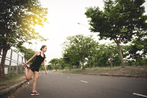 Soporte de mujer delgada asiática para estirar piernas Concepto de chica deportiva