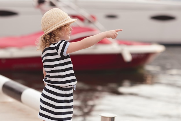 Soporte de niña niño divertido en el muelle del mar usar ropa casual