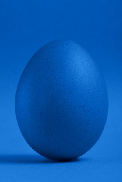 Foto un soporte pintado azul del huevo de pascua en un fondo azul