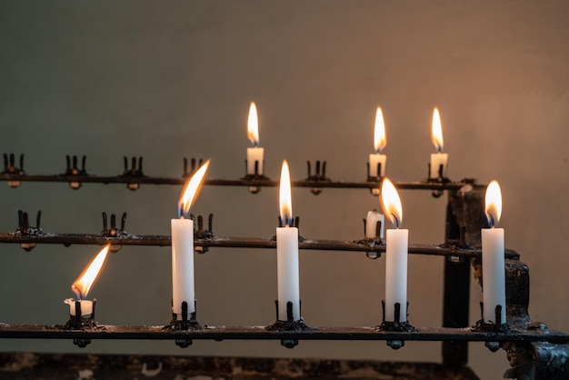 Soporte de velas de oración encendidas en la iglesia vieja