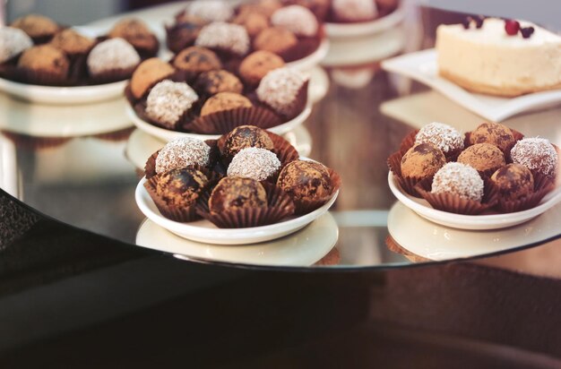 Soporte de vidrio con sabrosos dulces en la cafetería vista de cerca