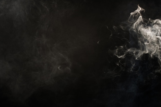 Sopros macios densos de fumaça branca e neblina sobre fundo preto, nuvens de fumaça abstratas, movimento turva fora de foco. Fumar golpes de máquina de gelo seco voa e esvoaçante no ar, textura de efeito