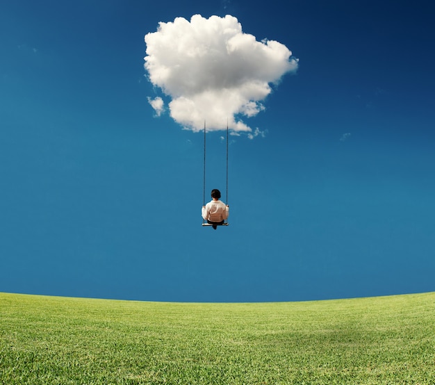 Foto sorglose geschäftsfrau auf einer schaukel in einer wolke